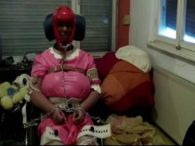Vorschaubild vom Amateurporno mit dem Titel "Im Rollstuhl festgeschnallte gewindelte Gummisklavin werden Masken verpaßt" von dompaar2005